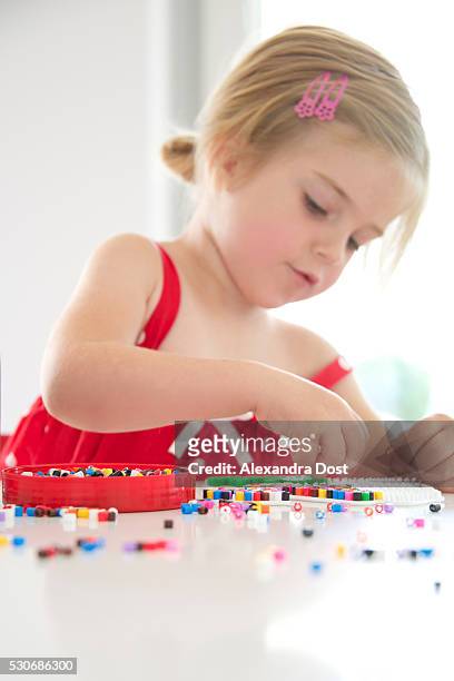 girl playing with ironing beads - alexandra dost stock-fotos und bilder
