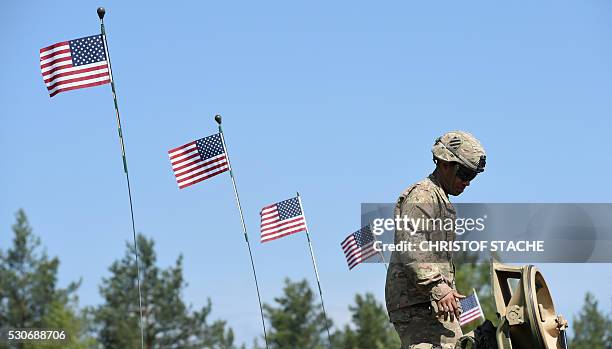 Soldier stands at a tank type "M1A2 SEP" which are decorated with US flags at a parking position at the training area in Grafenwoehr, near...