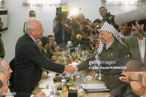 Israeli Prime Minister Yitzhak Rabin shakes Palestinian Authority President Yasser Arafat's hand at the Erez Checkpoint, on the border of the Gaza...