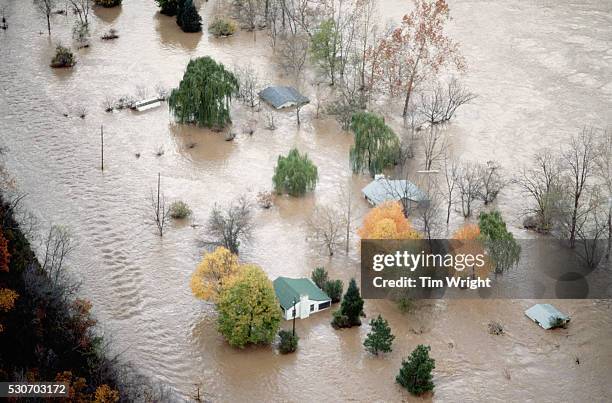 an aerial view of houses surrounded by flood water - flood foto e immagini stock