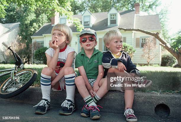 three brothers sitting on curb - wright brothers stock pictures, royalty-free photos & images