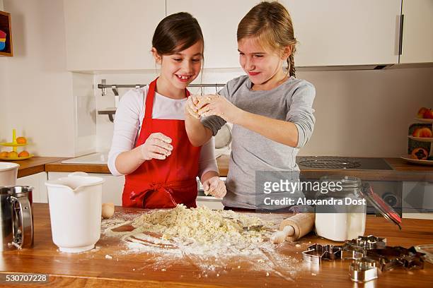 two girls making christmas cookies, munich, bavaria, germany - alexandra dost stock-fotos und bilder