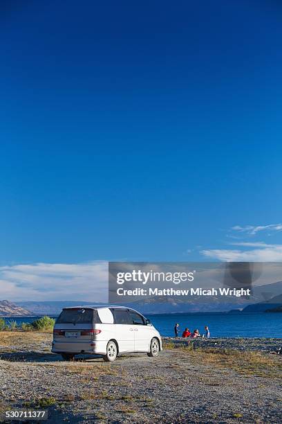 a couple sit and admire lake hawea. - road trip new south wales stock pictures, royalty-free photos & images