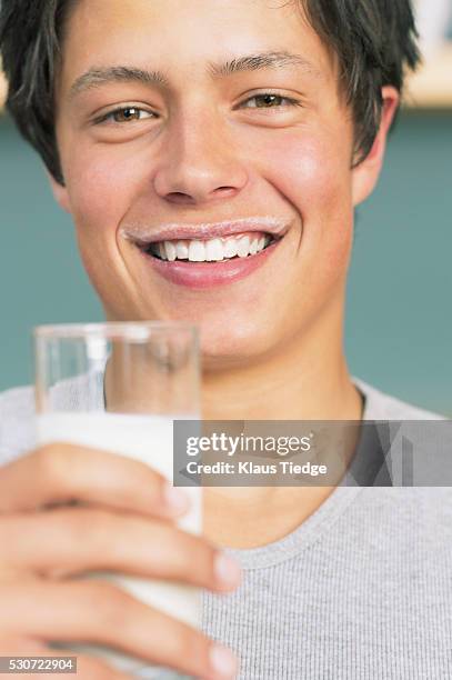 smiling man with milk mustache - milchbart stock-fotos und bilder