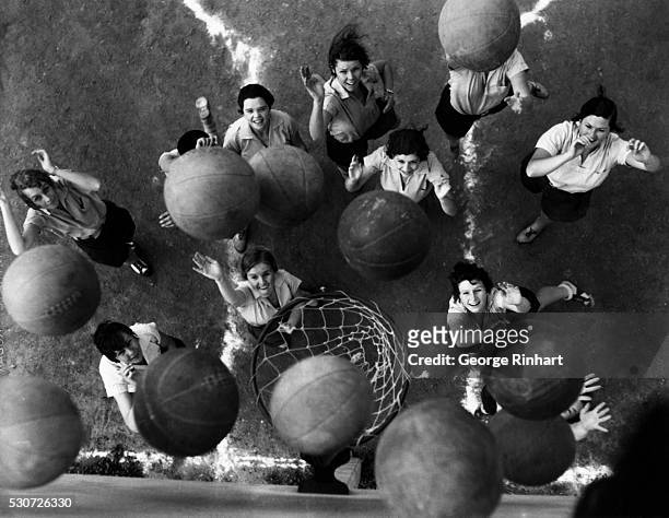 Dozen women basketball players throw balls at the hoop at once. The women are students at University of California at Los Angeles participating in...