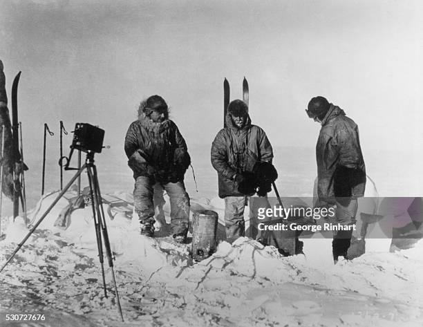 Members of the Rear Admmiral Byrd's Antarctic expedition pause on the ice for a brief rest after traveling on skis.