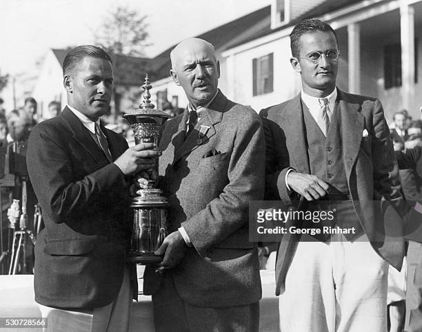 Bobby Jones receives the U.S. Amateur trophy from Findlay Douglas, the President of the U.S. Golf Association. Gene Homans lost to Jones in the final...