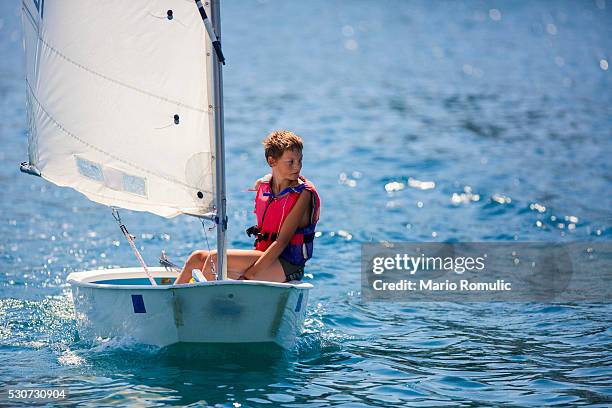 boy in a sailboat, hvar island, croatia - kid sailing imagens e fotografias de stock