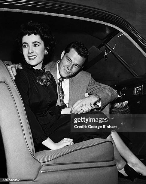 Photo shows Elizabeth Taylor with her fiancee, Conrad Nicholas Hilton, Jr., seated in a car, at the end of 1949 or early 1950.