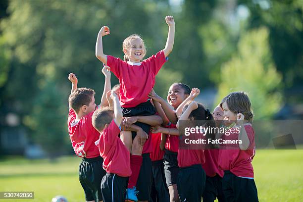 holding a teammate up in the air - een doelpunt maken stockfoto's en -beelden