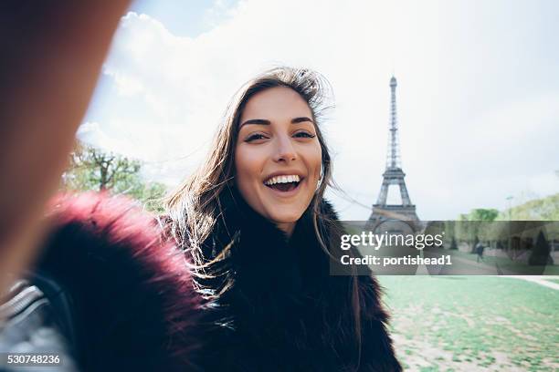 happy young woman making selfie - woman eiffel tower stock pictures, royalty-free photos & images