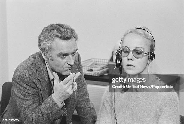 English actor John Thaw on left, pictured in character as Detective Inspector Jack Regan with actress Georgina Hale playing a telephonist during...