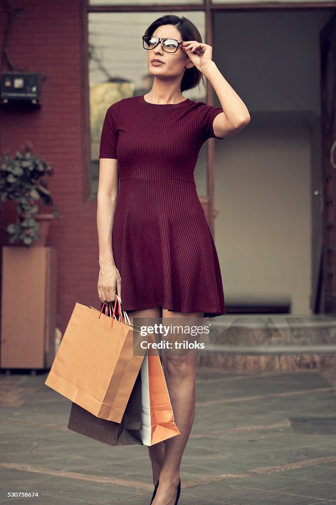 Young beautiful standing with shopping bags