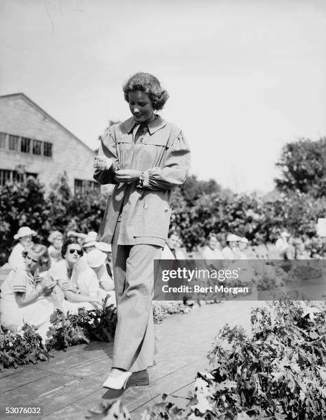 Eccentric American model and singer Edith Bouvier Beale walks a catwalk as she models a smock and matching pants outfit at the Easthampton Fair,...