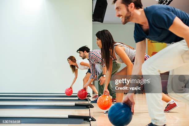 cheerful friends bowling together. - bowling alley stock pictures, royalty-free photos & images