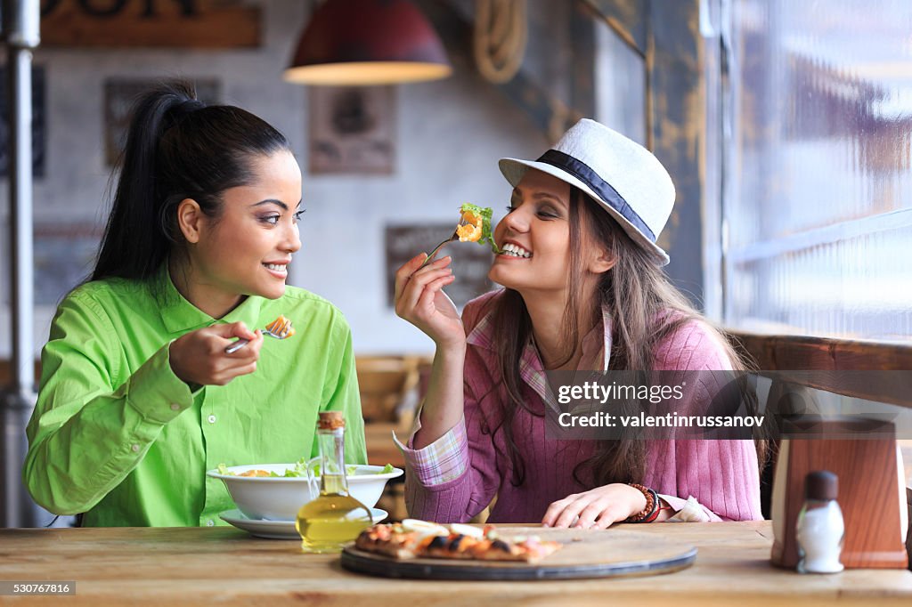 Two female friends having lunch in restaurant