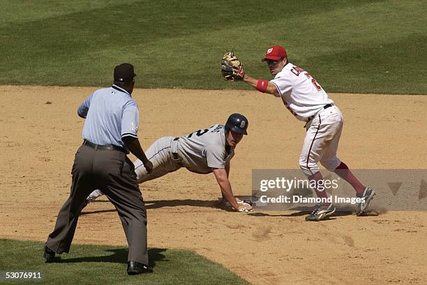 Jamey Carroll, of the Washington Nationals, show umpire Chuck Meriwether he has the ball after tagging out Greg Dobbs, of the Seattle Mariners, in...