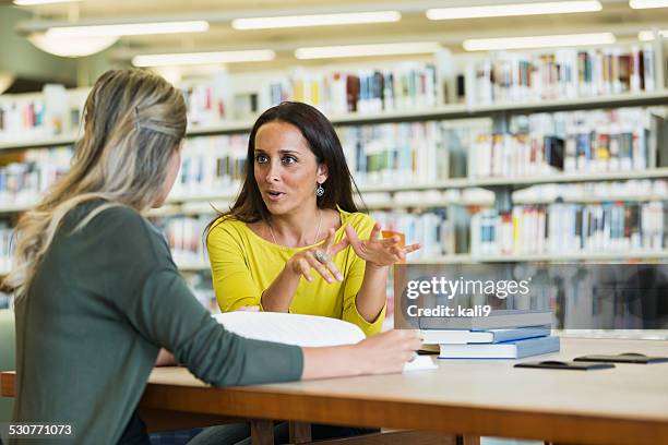 estudiantes adultos estudiando juntos en una biblioteca - teacher meeting fotografías e imágenes de stock