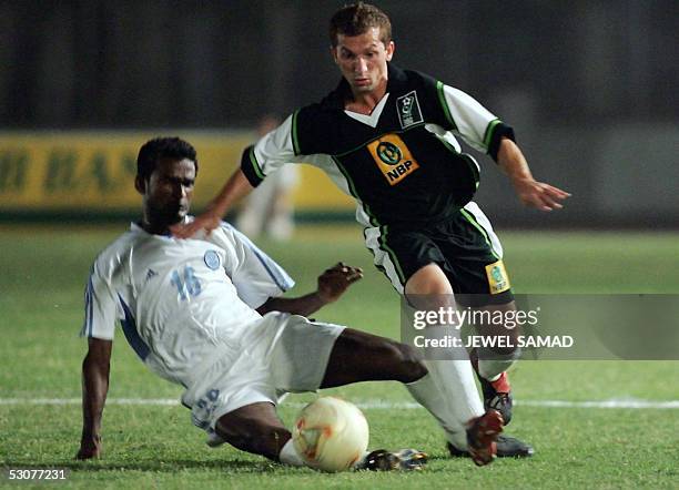 Indian midfielder Climax Lawrence tackles Pakistani striker Farooq Shah during the second match of the three-match football series between Pakistan...