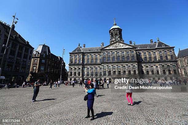 Tourists walk near the Royal Palace on May 11, 2016 in Amsterdam, Netherlands. The Royal Palace or Koninklijk Paleis Amsterdam or Paleis op de Dam in...