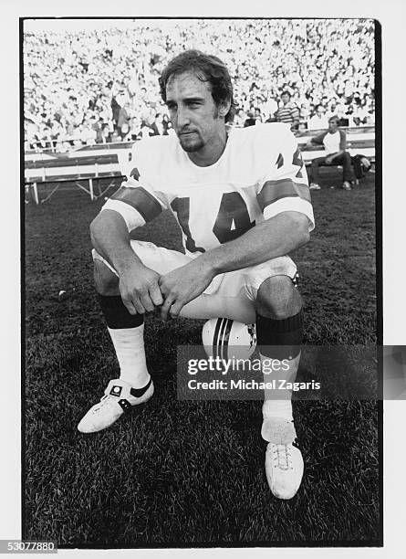 Steve Grogan of the New England Patriots sits on the sidelines against the Oakland Raiders during the 1976 AFC Divisional Playoff game at Oakland...