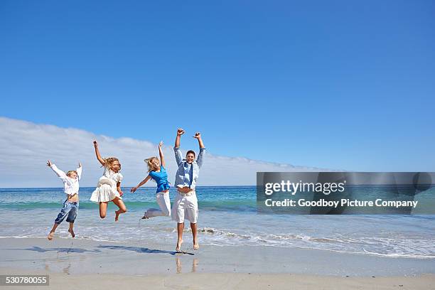 enjoying their beach trip - beach family jumping stock pictures, royalty-free photos & images