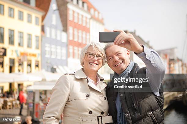 mature couple in a city. - copenhagen nyhavn stock pictures, royalty-free photos & images
