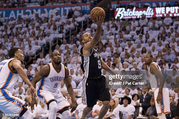 Tony Parker of the San Antonio Spurs runs past Oklahoma City Thunder players to dunk two points during Game Four of the Western Conference Semifinals...