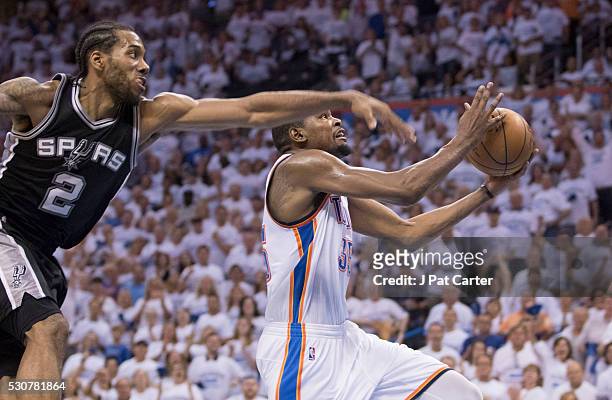 Kevin Durant of the Oklahoma City Thunder goes past Kawhi Leonard of the San Antonio Spurs for two points during Game Four of the Western Conference...