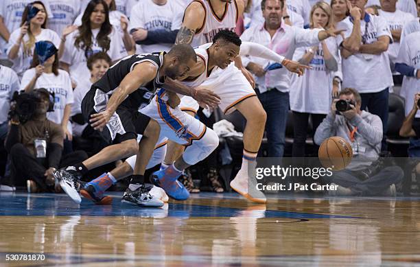 Tony Parker of the San Antonio Spurs and Russell Westbrook of the Oklahoma City Thunder chase a loose ball during Game Four of the Western Conference...