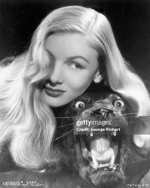 American actress, Veronica Lake , posing with the stuffed panther head from a panther skin rug. Undated promotional photo for Paramount Pictures...