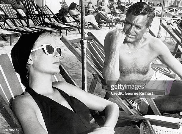 Cary Grant and Grace Kelly lounging on the beach in a scene from the 1955 classic To Catch a Thief.