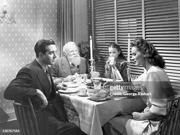 Left to right: Fred Gailey , Kris Kringle , Doris Walker and Susan Walker sit at the diner table during a scene from the 1947 20th Century Fox...