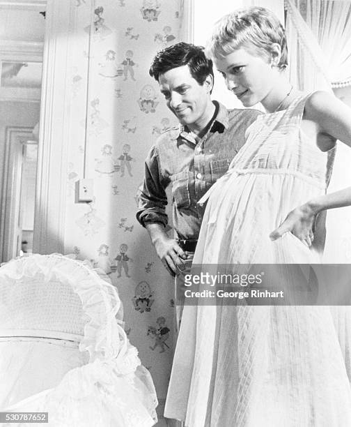 Pregnant Rosemary and her husband looking at their unborn child's bassinet. A scene from the 1968 Paramount movie, Rosemary's Baby.