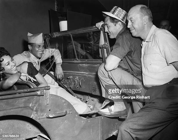 Robert Mitchum, center, and director-producer Otto Preminger , chat with Dorothy Dandridge and Harry Belafonte on the set of 'Carmen Jones' at 20th...