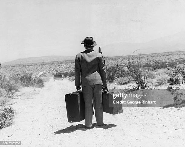 Judy Garland drives off into the desert after leaving Mickey Rooney stranded with his luggage and standing in the dust in the 1943 musical comedy,...