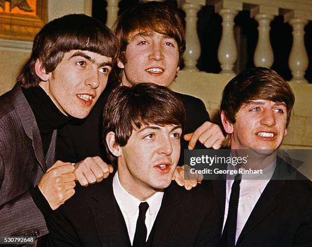 The Beatles smiling together. From left to right: George Harrison, John Lennon , Paul McCartney , and Ringo Starr.