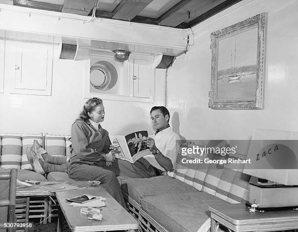 Errol Flynn and his wife, Nora Eddington, in the lounge of yacht, Zaca.
