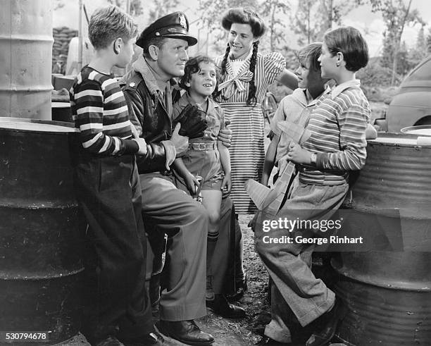 Hero. Spencer Tracy holds these youngsters spellbound with his tales of air battles in this scene from A Guy Named Joe, in which he co-stars with...