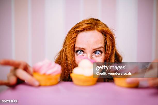 young woman really wants to eat cupcakes - wamt stock pictures, royalty-free photos & images