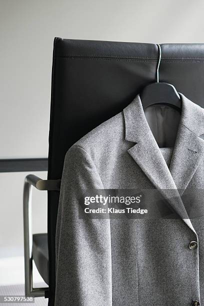 blazer hanging on office chair - metallic jacket stock pictures, royalty-free photos & images