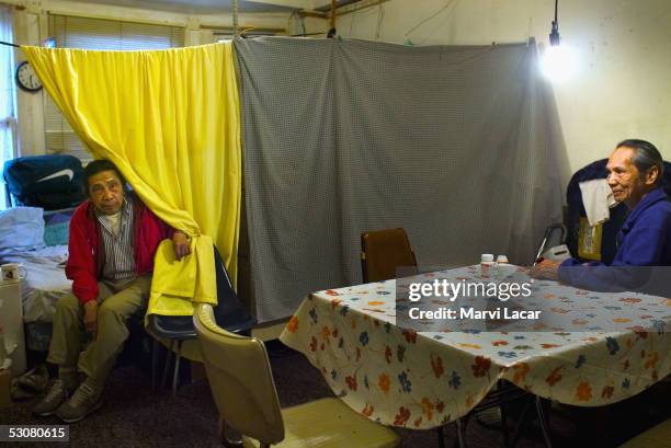 Sixto Gagni and Pedro Dosono sit in their home May 4, 2005 in San Francisco. To save money on rent, the two share a converted one-bedroom apartment...