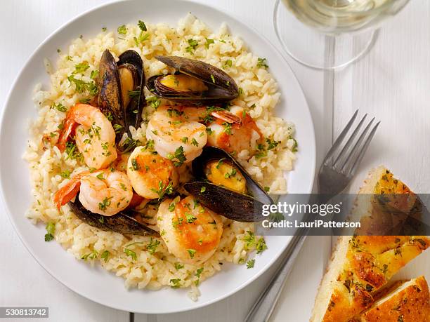 seafood risotto with fresh parsley and focaccia bread - vis en zeevruchten stockfoto's en -beelden