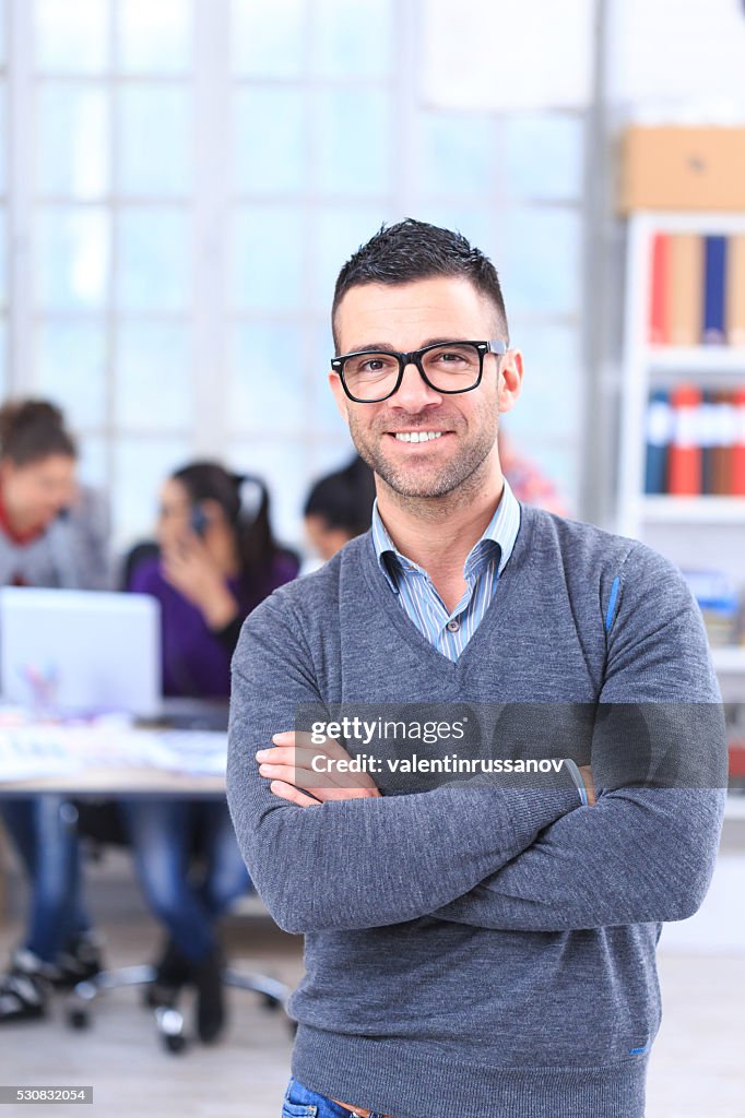 Portrait of smiling young man at the office-vertical