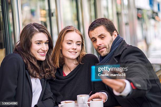 young people making selfie in parisien cafe - café parisien stockfoto's en -beelden