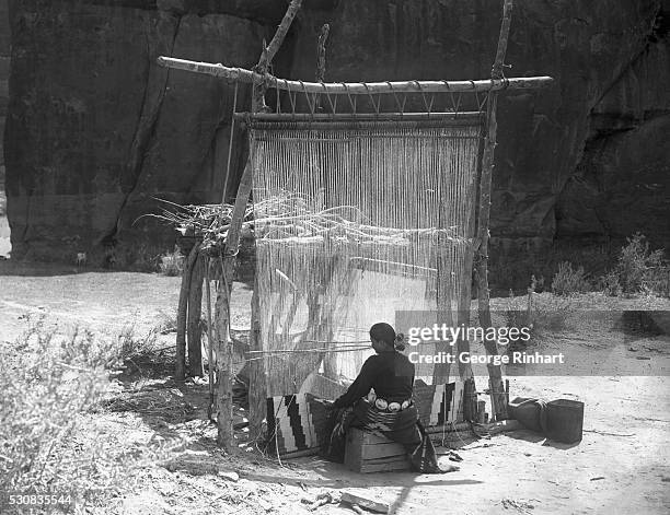 Navajo girl weaving a rug. Note the design at the bottom of the weave. Time is no object, each strand of the weave is hammered close by a curved...