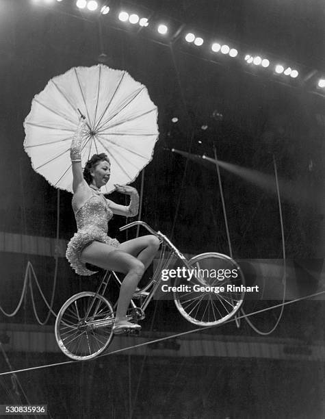 Circus high-wire cyclist with parasol. Undated photograph. BPA2# 5077