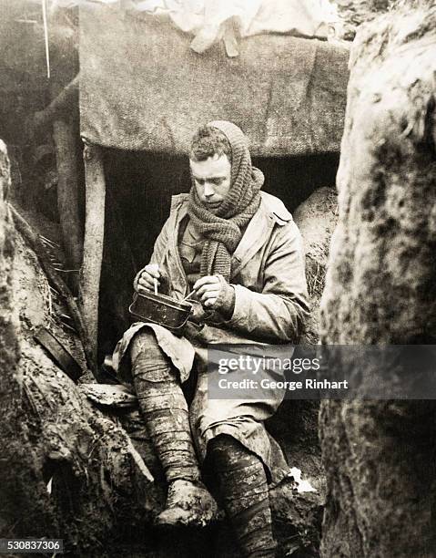 Picture shows a British solider eating his dinner in the trenches during World War I. Undated photo. BPA2# 5602.
