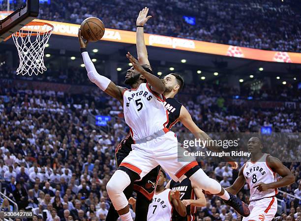 DeMarre Carroll of the Toronto Raptors shoots the ball and is fouled by Josh McRoberts of the Miami Heat in the first half of Game Five of the...