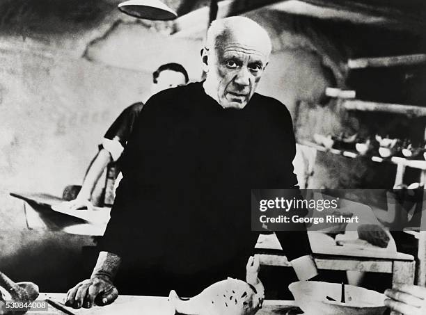 Spanish painter and sculptor Pablo Picasso, who helped develop many styles of the twentieth century at work in his studio.